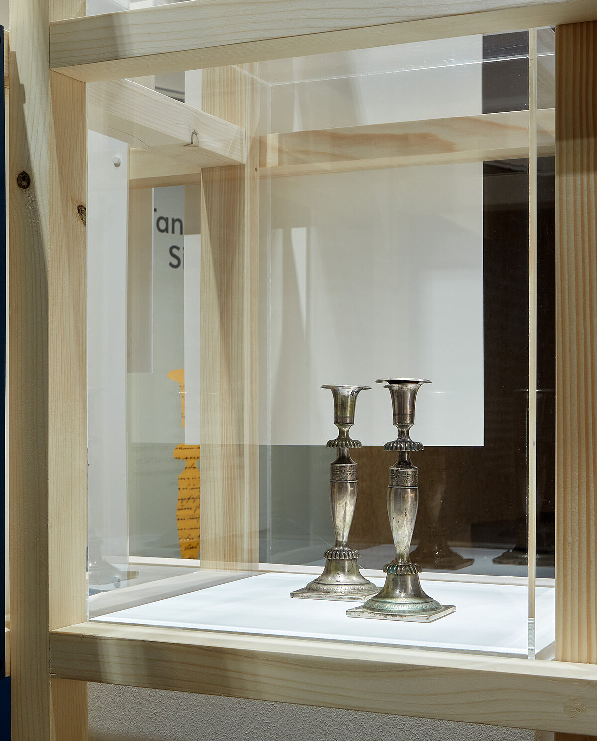 Blick in die Ausstellung "Tante Olgas Silberleuchter", mittig sind in einer Vitrine zwei silberne Leuchter zu sehen, Foto: Eva Jünger / Jüdisches Museum München