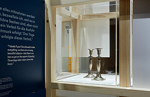 Blick in die Ausstellung "Tante Olgas Silberleuchter", mittig sind in einer Vitrine zwei silberne Leuchter zu sehen, Foto: Eva Jünger / Jüdisches Museum München