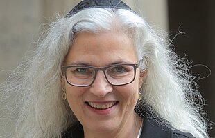 Porträt der Rabbinerin Elisa Klapheck, sie trägt lange weißgraue lange Haare und eine Kippa auf dem Hinterkopf, Foto: Rafael Herlich